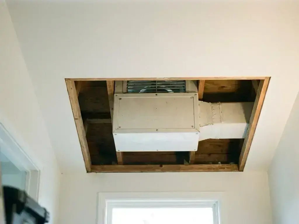 Technician mounting attic fan in Over-the-Rhine