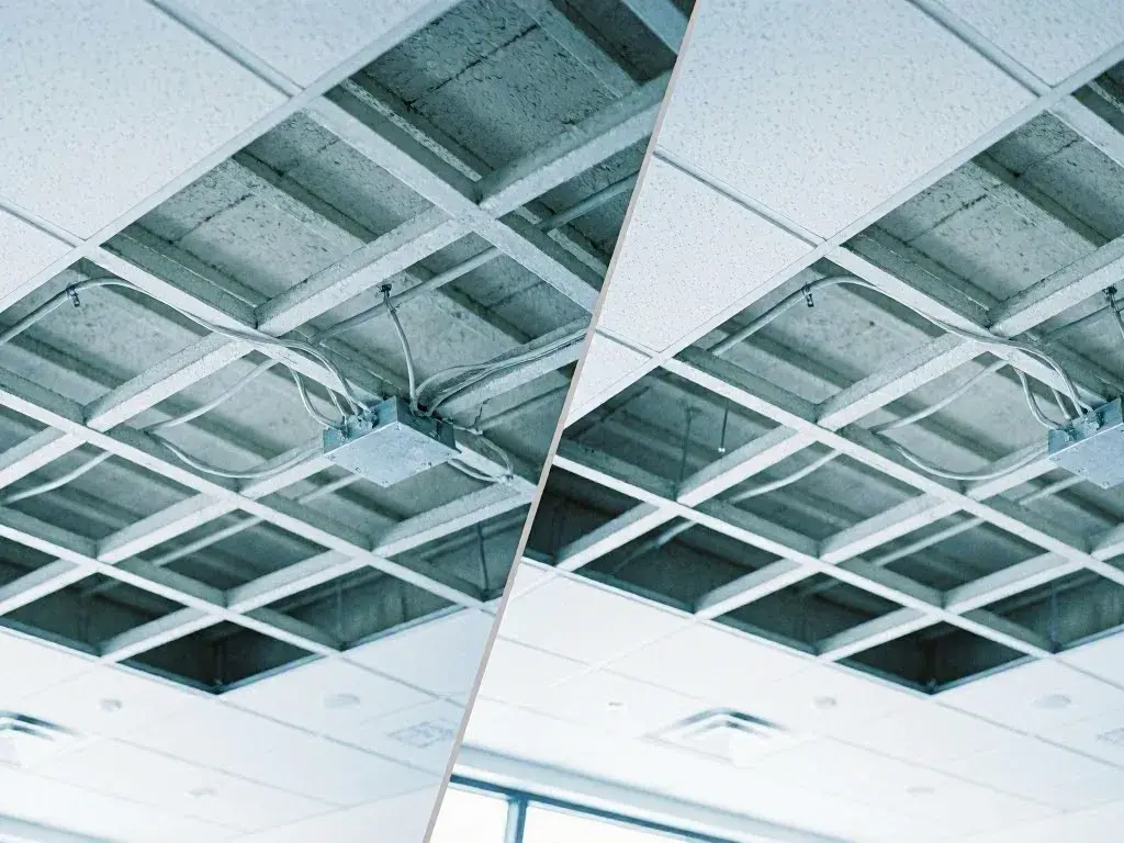 Exposed ceiling grid, wiring, and dropped tiles in a bright room