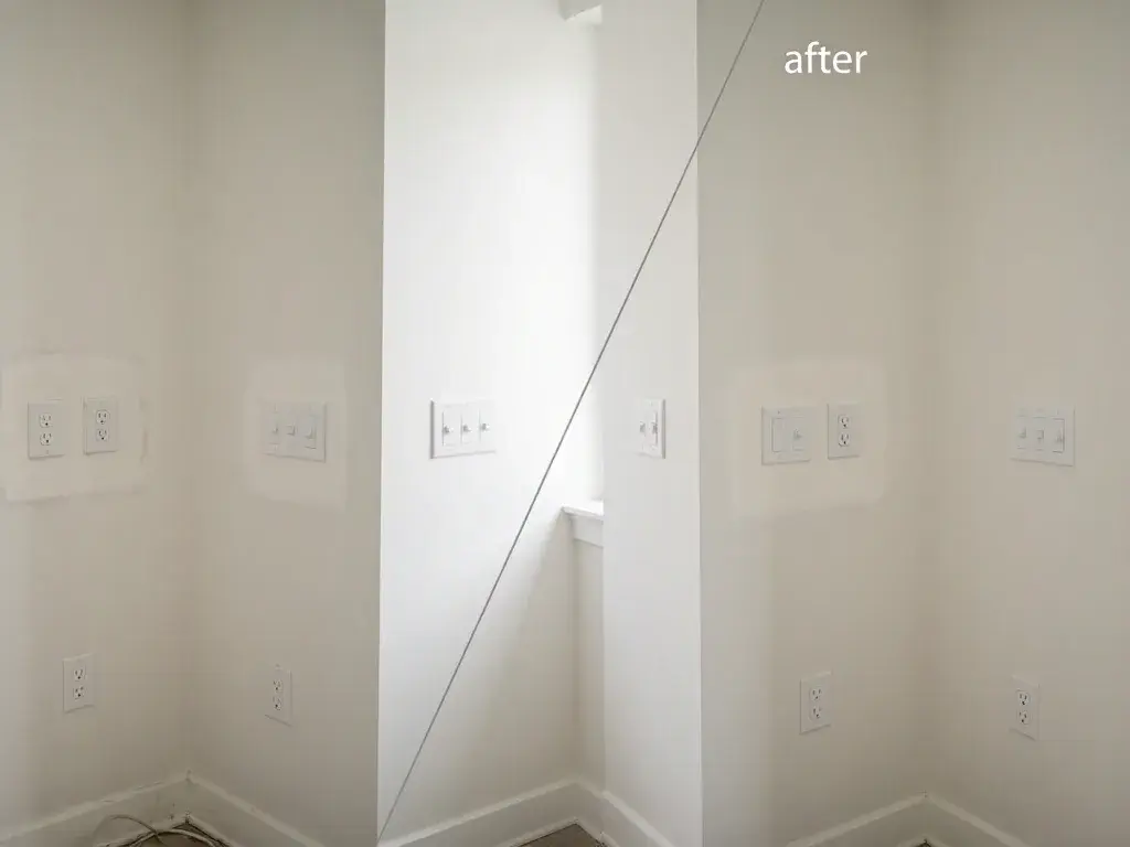 Room corner with white walls, electrical outlets, and a diagonal mirror showing