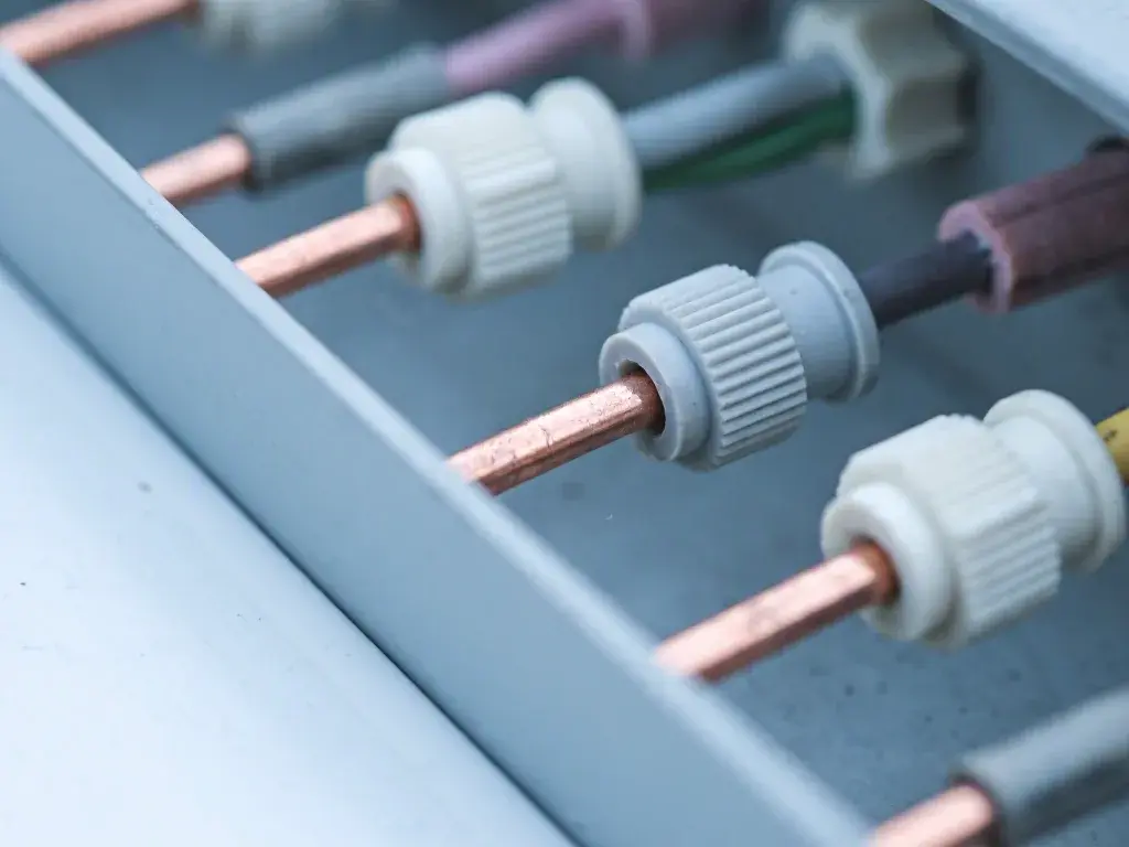 Close-up of copper wires with white connectors inside an electrical panel